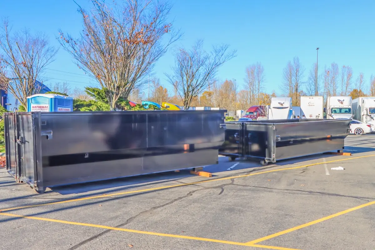 Professional dumpster rental service with roll-off container on residential driveway in El Paso